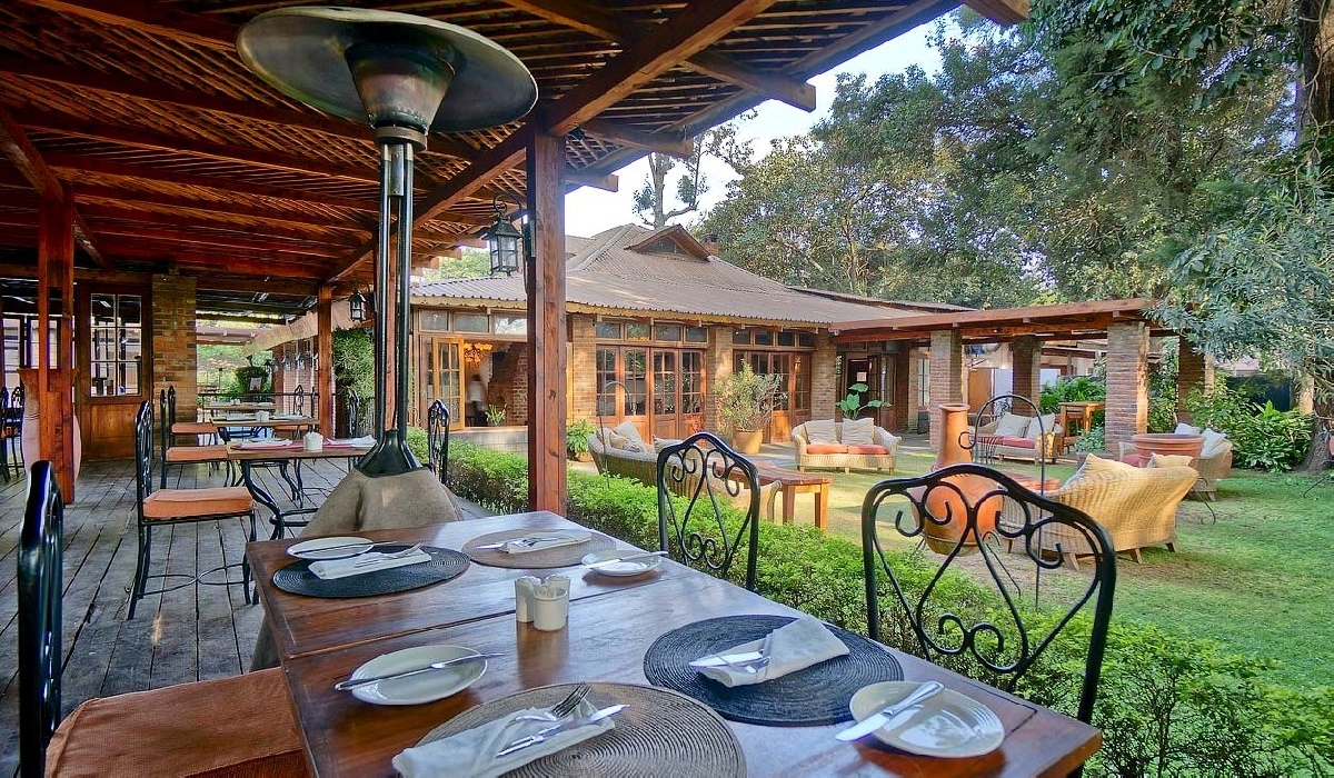 Terrasse ouverte sur le jardin de l'Arusha Coffee Lodge