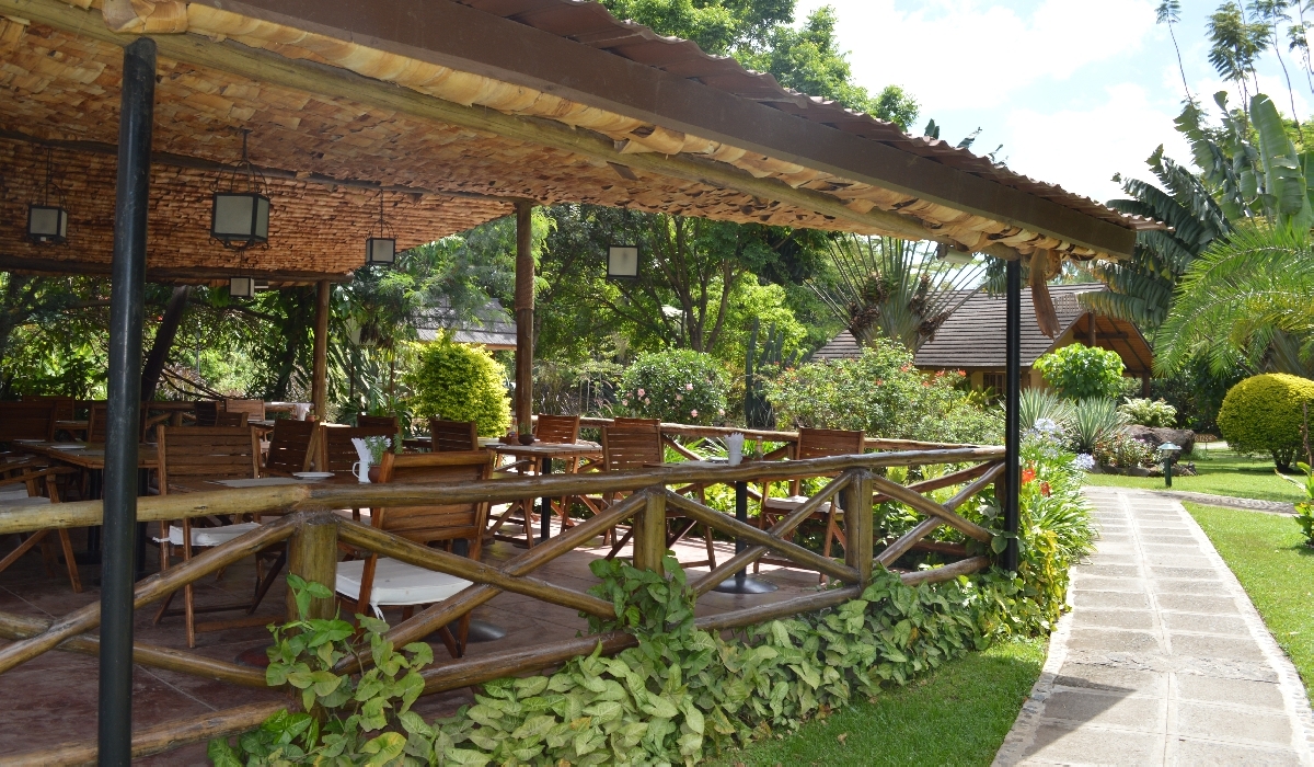 Terrasse du restaurant ouverte sur les jardins de l'Arumeru River Lodge